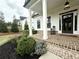 Front porch with brick flooring and manicured landscaping, offers a welcoming entry to the home at 305 Red Gate Ln, Canton, GA 30115