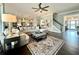 Open-concept living room featuring hardwood floors and a stylish area rug with a coffered ceiling fan at 305 Red Gate Ln, Canton, GA 30115