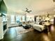 Spacious living room with a fireplace, large windows, ceiling fan, and seamless connection to the kitchen at 305 Red Gate Ln, Canton, GA 30115