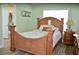 Cozy bedroom showcasing a wooden bed frame, complemented by a matching bedside table and soft lighting at 3440 Camelot Way, Loganville, GA 30052