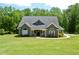 Charming grey home with a manicured lawn, inviting front porch, and meticulously maintained landscaping at 3440 Camelot Way, Loganville, GA 30052