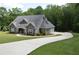 Charming gray two-story home with manicured lawn and a long driveway at 3440 Camelot Way, Loganville, GA 30052