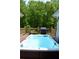 Inviting backyard deck featuring a sleek swim spa and a built-in outdoor grill at 3440 Camelot Way, Loganville, GA 30052