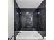 Modern bathroom with a luxurious black tiled shower and chrome fixtures at 3690 Darrah Sw Way, Atlanta, GA 30331