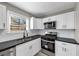 Modern kitchen featuring white cabinets, stainless steel appliances, and dark countertops at 3690 Darrah Sw Way, Atlanta, GA 30331
