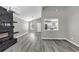 Open-concept living room featuring modern light fixtures, a fireplace, and an open view to the kitchen at 3690 Darrah Sw Way, Atlanta, GA 30331