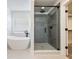 Bright bathroom featuring a modern soaking tub and glass-enclosed shower with gray tiling at 4035 Hosch Retreat Dr, Buford, GA 30519