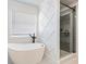 Bathroom boasting a soaking tub and tiled shower behind diamond pattern accent wall at 4035 Hosch Retreat Dr, Buford, GA 30519