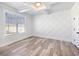 Bright bedroom features a decorative accent wall, coffered ceiling, and wood-look floors at 4035 Hosch Retreat Dr, Buford, GA 30519