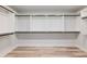 Spacious walk-in closet with custom shelving and ample storage space on wood floor at 4035 Hosch Retreat Dr, Buford, GA 30519