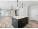 Open-concept kitchen with center island that has seating, a staircase in view, and modern lighting at 4035 Hosch Retreat Dr, Buford, GA 30519