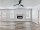 Bright living room with a fireplace, wood-look tile flooring, ceiling fan, and modern design at 4035 Hosch Retreat Dr, Buford, GA 30519