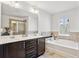 Bright bathroom featuring a soaking tub and a double sink vanity at 7554 Roseberry Way, Lithonia, GA 30038