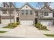 Attractive townhome with a two-car garage, a brick facade, a concrete driveway, and tasteful landscaping at 7554 Roseberry Way, Lithonia, GA 30038