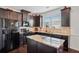 Modern kitchen featuring dark cabinets, granite countertops, an island, and stainless steel appliances at 7554 Roseberry Way, Lithonia, GA 30038