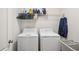 Well-equipped laundry area with washer, dryer, storage shelf, and lots of hangers at 7554 Roseberry Way, Lithonia, GA 30038