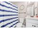 Cozy bathroom features a blue striped curtain, white vanity, toilet, and modern fixtures providing a clean and inviting space at 20 Tuscany Dr, Mansfield, GA 30055