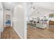 Open concept living room with vaulted ceilings, modern fan, hardwood floors, and views of the kitchen and dining area at 20 Tuscany Dr, Mansfield, GA 30055