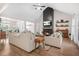 Bright living room with a vaulted ceiling, fireplace, and hardwood floors, adjacent to the kitchen at 20 Tuscany Dr, Mansfield, GA 30055