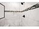 Close up of a shower showcasing its rainfall shower head, built-in niche, bench, and decorative tile border at 20 Tuscany Dr, Mansfield, GA 30055