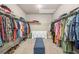 Spacious walk-in closet with ample storage, shelves, hanging rods, dresser, and a central bench with a carpeted floor at 20 Tuscany Dr, Mansfield, GA 30055