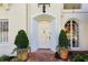 Charming front entrance with brick walkway, arched doorway, and manicured potted plants at 41 Palisades Ne Rd, Atlanta, GA 30309
