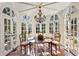 Bright sunroom features brick flooring, an ornate chandelier, and multiple arched windows with views of the outdoors at 41 Palisades Ne Rd, Atlanta, GA 30309