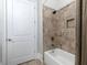 Well-lit bathroom features a white tub with stone-patterned tiling and a recessed niche at 4845 Josie Way, Acworth, GA 30101