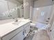 Bright bathroom features white cabinets, sink, shower-tub, and light gray tile flooring at 1367 Fern Ridge Ct # 31, Norcross, GA 30093