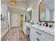 Bright bathroom featuring double vanities, marble countertops, and modern fixtures with wood look tile flooring at 2168 Berryhill Se Cir, Smyrna, GA 30082