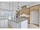 Elegant kitchen boasts a large island, pendant lighting, light wood cabinets, and herringbone backsplash at 2637 Camphor Se Xing # 83, Smyrna, GA 30080