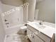 Well-lit bathroom featuring a tub with a shower, a toilet, and a vanity sink at 1397 Fern Ridge Ct # 34, Norcross, GA 30093