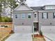 Charming townhome featuring a gray painted brick facade, an attached garage, and a well-manicured lawn at 1397 Fern Ridge Ct # 34, Norcross, GA 30093