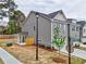 Side view of townhome with a covered porch, gray siding, street sign, and green space at 1397 Fern Ridge Ct # 34, Norcross, GA 30093