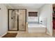 Bathroom featuring a tiled shower and soaking tub under a window at 2096 Hamilton Lake Pkwy, Buford, GA 30519