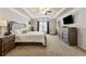 Spacious main bedroom with a decorative tray ceiling, ceiling fan, and mounted television at 2096 Hamilton Lake Pkwy, Buford, GA 30519