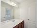 Well-lit bathroom featuring a large mirror, wood cabinets and a white countertop and trim at 5615 Toccoa Dr, Douglasville, GA 30135
