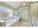 Well-lit bathroom featuring a soaking tub, glass shower, white cabinets, vanity, and tile floor at 5615 Toccoa Dr, Douglasville, GA 30135