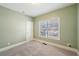 Cozy bedroom with neutral carpet, light green walls, and a window at 5615 Toccoa Dr, Douglasville, GA 30135