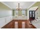 Elegant dining room with wainscoting, hardwood floors, chandelier, and windows overlooking the front yard at 5615 Toccoa Dr, Douglasville, GA 30135
