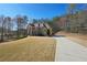 Large brick home featuring a long driveway, well-maintained lawn, and a backdrop of trees at 5615 Toccoa Dr, Douglasville, GA 30135