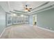 Spacious main bedroom with a tray ceiling, many windows with white shutters, and ensuite bath at 5615 Toccoa Dr, Douglasville, GA 30135