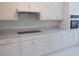 Well-lit kitchen with white cabinets, ample counter space, and stainless steel appliances at 606 Se Riverview Dr # 606, Marietta, GA 30067