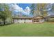 A large, grassy backyard with mature trees and a covered patio at 814 Bank St, Smyrna, GA 30080
