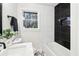 Contemporary bathroom with white and black tile, white vanity, and a bathtub at 814 Bank St, Smyrna, GA 30080