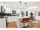 Modern kitchen with white cabinets, stainless steel appliances, a kitchen island, and stylish pendant lighting at 814 Bank St, Smyrna, GA 30080
