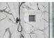 Close up of the shower showing marble tile, shower head, and shelf at 814 Bank St, Smyrna, GA 30080
