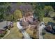 Aerial view of a brick home with pool, long driveway, mature trees, manicured lawns and neighboring houses at 1564 Beaver Creek Lane, Snellville, GA 30078