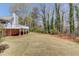 Expansive backyard with mature trees, perfect for outdoor activities with home and deck in background at 1564 Beaver Creek Lane, Snellville, GA 30078