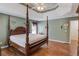 A spacious main bedroom features a wooden four poster bed, wooden floors, and green walls at 1564 Beaver Creek Lane, Snellville, GA 30078